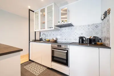 a kitchen with white cabinets and a stove top oven at Panoramic Sea View - 1 Bdr Promenade des Anglais in Nice