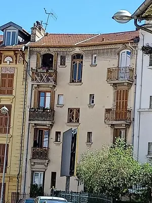 a large building with balconies on the side of it at Arty room in Nice