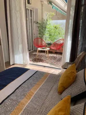 a bedroom with a door open to a patio with chairs at Beautiful flat Nice - Palais Meyerbeer at 2min beach Negresco in Nice