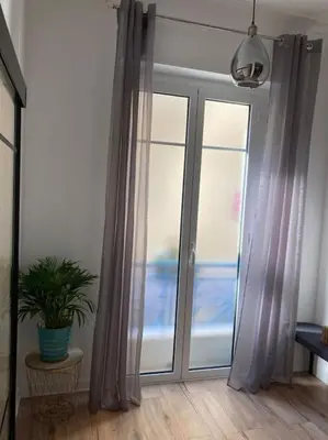 a room with a sliding glass door with a potted plant at Beautiful flat Nice - Palais Meyerbeer at 2min beach Negresco in Nice