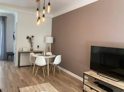 a living room with a table and a flat screen tv at Beautiful flat Nice - Palais Meyerbeer at 2min beach Negresco in Nice
