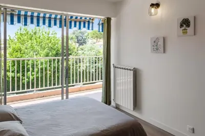 a bedroom with a bed and a large window at Le Mimosa - Calm - Spacious - 200m from the sea - Parking in Cagnes-sur-Mer