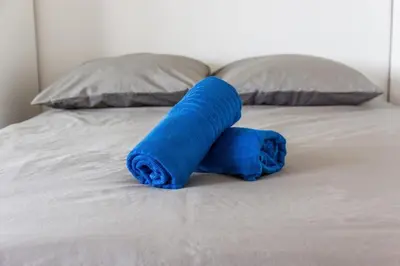 a blue towel sitting on top of a bed at Le Mimosa - Calm - Spacious - 200m from the sea - Parking in Cagnes-sur-Mer