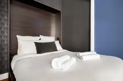 a large white bed with two towels on it at Raffinement en pleine ville in Nice
