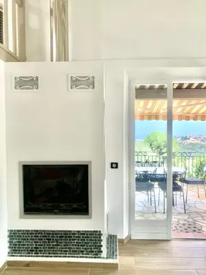 a living room with a fireplace and a patio at THE GREEN OASIS breathtaking sea views, swimming pool, privacy in Villa Liliana in Tourrette-Levens