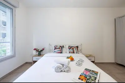 a white bedroom with a bed with a window at Appartement nice in Nice