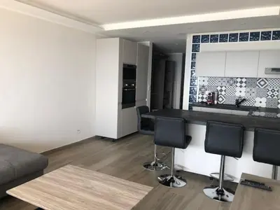 a kitchen and living room with a counter and chairs at Eros in Nice