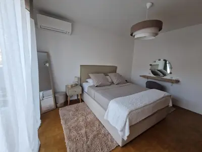 a white bedroom with a bed and a mirror at Charmant 2 pièces Centre Ville in Nice