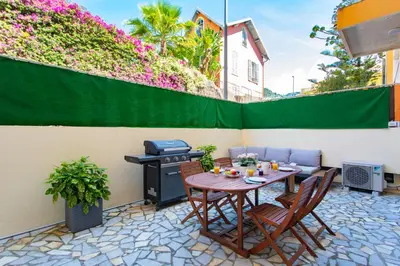 a patio with a table and chairs and a grill at 86m- Spacious 3 room apartment with large terrace in Villefranche-sur-Mer