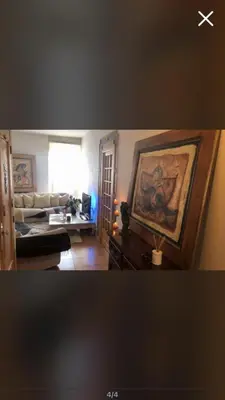 a living room with a couch and a painting on the wall at Room near Nice Port in a shared apartment in Nice