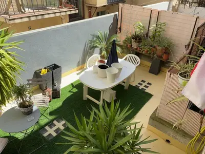 a table and chairs on a balcony with plants at Room for NUDISTS near Nice port in a shared apartment in Nice