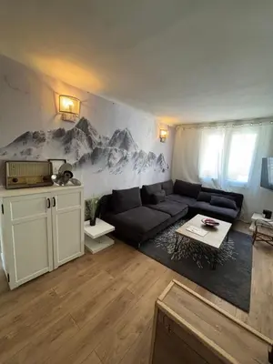 a living room with a couch and a mountain mural at Appartement confortable et cosy sur le port de Nice in Nice