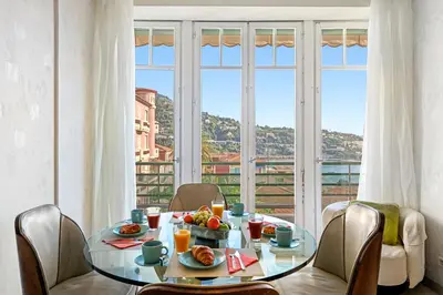 a dining room with a table with food on it at 4 pièces vue mer, 6 pers, balcon, WiFi, garage in Villefranche-sur-Mer