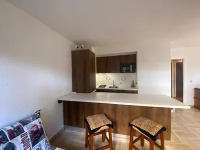 a kitchen with a counter and two chairs in a room at Cros de Cagnes Pins Sud Évasion in Cros-de-Cagnes