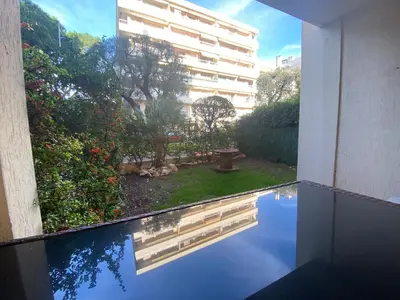 a reflection of a building in a pool of water at Cros de Cagnes Pins Sud Évasion in Cros-de-Cagnes