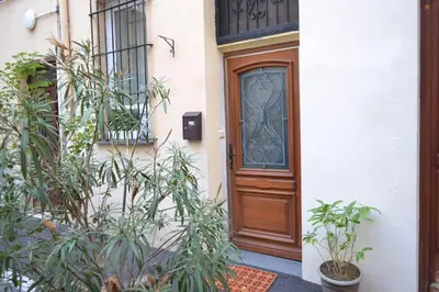 a wooden door of a house with plants in front at Magnifique appartement 2 pièces - Port de Nice in Nice