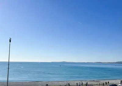 a group of people standing on a beach near the water at t3 cagnes sur mer in Cagnes-sur-Mer