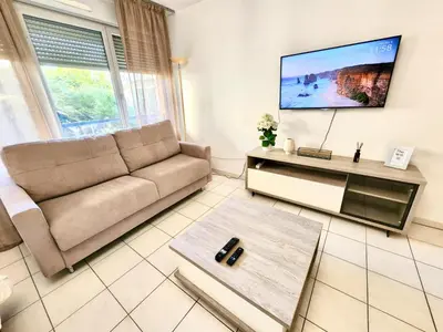 a living room with a couch and a flat screen tv at Sunny Escape in Nice