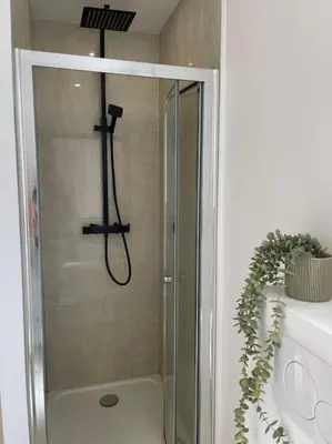 a shower with a glass door in a bathroom at Appartement à 2 pas de la mer et Parking privé in Nice