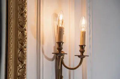 a pair of candles on a wall next to a mirror at Appartement Belle Époque cœur de ville -AC- in Nice