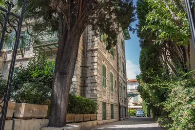 a brick building with a tree next to a street at Appartement Belle Époque cœur de ville -AC- in Nice