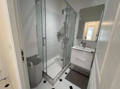 a white bathroom with a shower and a sink at Sunny Gambetta with 3 air conditionings in Nice