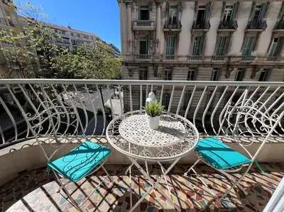 a balcony with a table and chairs on a balcony at Sunny Gambetta with 3 air conditionings in Nice
