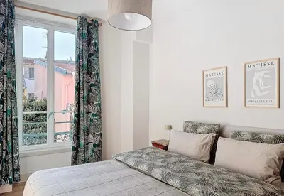 a bedroom with a bed and a window at Charming 2-Bedroom Retreat Near City Center with Excellent Transport Links in Nice