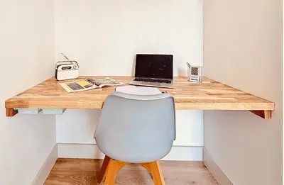 a wooden desk with a laptop and a chair at Charming 2-Bedroom Retreat Near City Center with Excellent Transport Links in Nice
