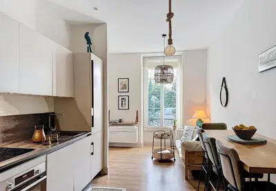 a kitchen with a table and a dining room at Charming 2-Bedroom Retreat Near City Center with Excellent Transport Links in Nice