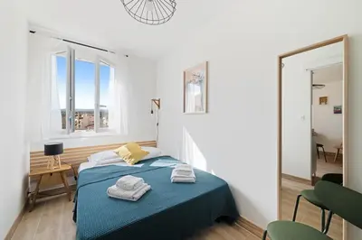 a bedroom with a bed and two chairs and a window at Vista Nissa - À Quelques Pas du Port in Nice