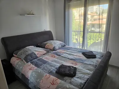 a bed in a bedroom with a couch and a window at L'escapade vers le bien-être in Nice