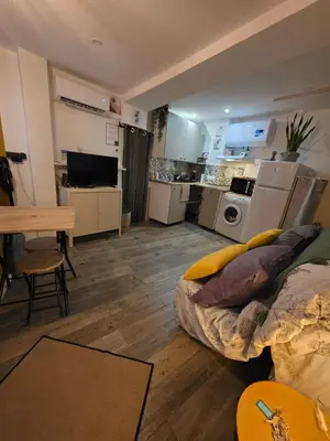 a living room with a bed and a kitchen at Atypique studio en bas du Château in Cagnes-sur-Mer