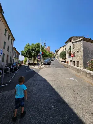 a young boy is walking down a street at Atypique studio en bas du Château in Cagnes-sur-Mer