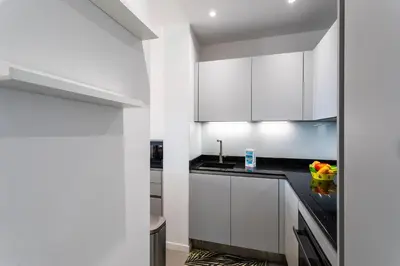 a kitchen with white cabinets and black counter tops at Esterel AP4431 By Riviera Holiday Homes in Villefranche-sur-Mer