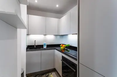 a kitchen with white cabinets and a black counter top at Esterel AP4431 By Riviera Holiday Homes in Villefranche-sur-Mer