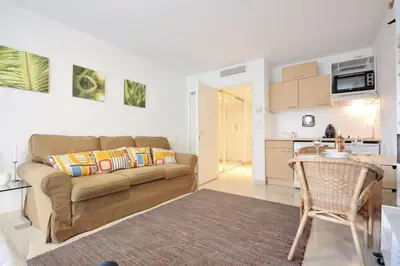 a living room with a couch and a kitchen at Le Palais de Med Studio Promenade des Anglais in Nice