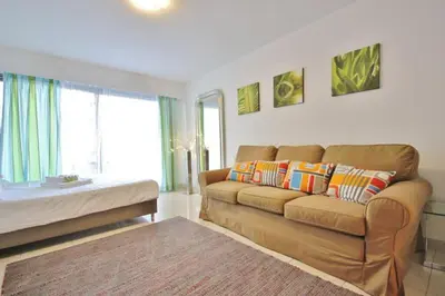 a living room with a couch and a large window at Le Palais de Med Studio Promenade des Anglais in Nice