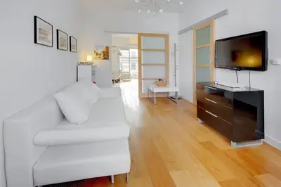 a living room with a white couch and a flat screen tv at MyrAzur Carre d'Or in Nice