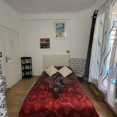 a bedroom with a bed with a red comforter at Studio centre ville in Nice