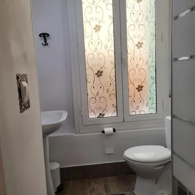 a bathroom with a toilet and a sink and a window at Studio centre ville in Nice