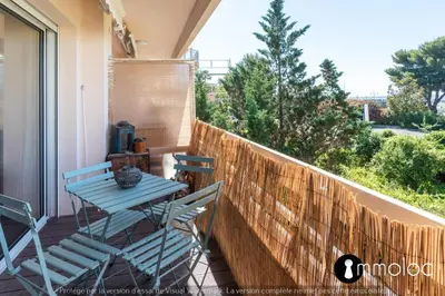 a blue table and chairs on a balcony with a view at Air-conditioned apartment facing the port of Saint Laurent with 2 bedrooms in Saint-Laurent-du-Var