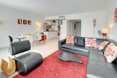 a living room with a black couch and a red rug at Villa Kappas - B42 Promenade des Anglais in Nice