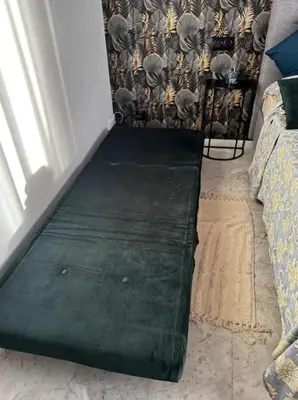 a green bench in a room with a bed at Studio en bord de mer, Plage 20m, Clim in Cagnes-sur-Mer