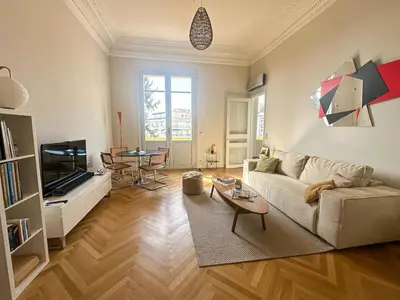 a living room with a couch and a table at Appartement exceptionnel belle époque avec grande terrasse plein sud in Nice