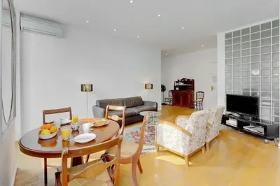 a living room with a table and chairs and a television at Rue Fodere location Port area in Nice