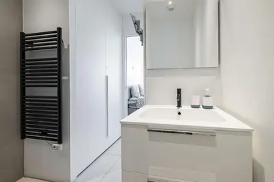 a white bathroom with a sink and a mirror at Royal Riviera in Nice