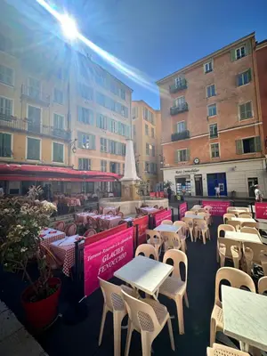 an outdoor patio with tables and chairs and buildings at Vieux Nice in Nice