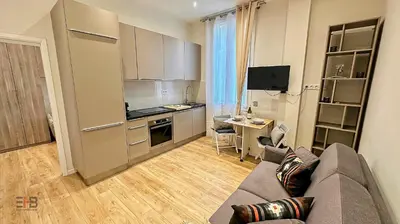 a living room with a couch and a kitchen at Le Petit Saint Barth- Easy Home Booking in Nice