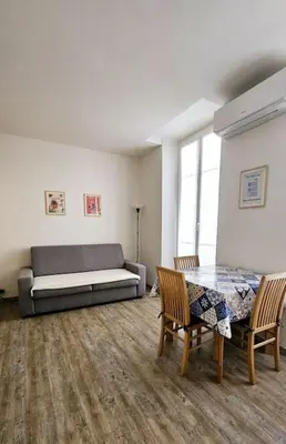 a living room with a bed and a table and chairs at Studio Nice Centre - Climatisation in Nice